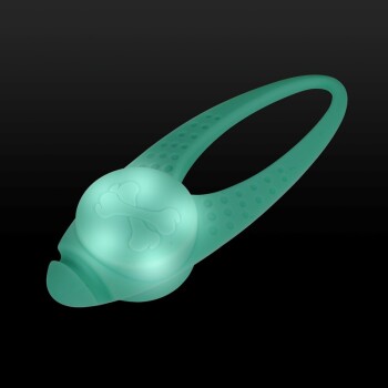 Ein leuchtendes türkisfarbenes Hundespielzeug in Form eines Knochens, mit einem strukturierten Griff und einem runden Zentrum mit einem Knochenmuster, auf einem schwarzen Hintergrund.