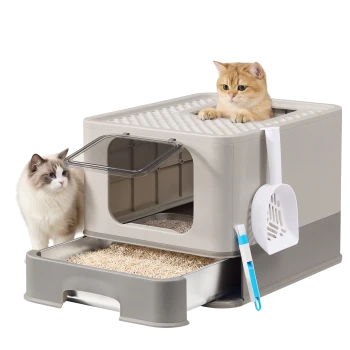 Beige Top-Entry-Katzentoilette mit herausziehbarer Schale, weißer Schaufel und Bürste; orange Kätzchen obenauf und fluffige weiße Katze daneben
