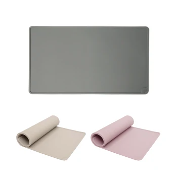 Eine graue Futtermatte für Haustiere wird oben gezeigt, mit einer gerollten beigen Matte links und einer gerollten rosa Matte rechts.