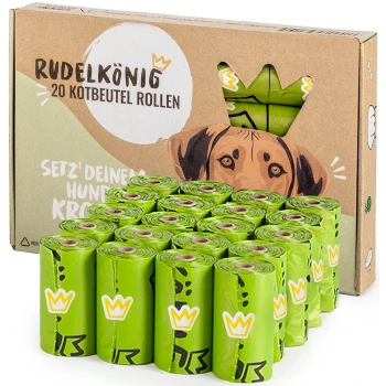 Grüne kompostierbare Hundekotbeutel, gestapelt vor einem Karton mit der Aufschrift "RudelKönig POOP BAGS," mit verspielten Illustrationen.