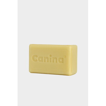 Gelbe rechteckige Seife mit eingeprägtem Schriftzug „Canina“ auf weißem Hintergrund.