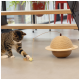 Un chat tabby joueur interagit avec un jouet en forme de planète fait de corde et de bois, avec une balle suspendue et une plume.