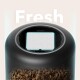 Oberseite eines schwarzen automatischen Haustierfutterspenders mit rechteckigem Filter im Deckel, darunter sichtbares Trockenfutter und oben das Wort 'Fresh'.