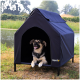 Schwarz-brauner Hund liegt in einem schwarzen erhöhten Hundehäuschen mit „lionto“ Logo, draußen in der Nähe eines Teichs und Grünflächen.