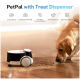 Ein Hund nähert sich einem PetPal-Gerät mit einem Leckerli-Spender auf einem Holzboden, das eine 2,5K-Kamera und eine Zwei-Wege-Kommunikation bietet.