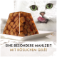 Weißer Kater mit grünen Augen leckt sich die Lippen neben gewürfeltem Fleischgelee; sichtbarer Text: "EINE BESONDERE MAHLZEIT, MIT KÖSLICHEM GELÉE".