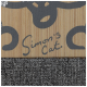 Produit en bois pour animaux avec un design ludique représentant un visage de chat et le texte 'Simon's Cat.' sur un fond gris texturé.