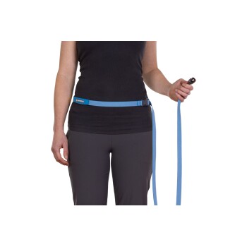 Eine Frau trägt ein schwarzes Tanktop und graue Hosen und hält eine blaue Hundeleine, die an einem passenden Hüftgurt mit der Aufschrift "RUFFWEAR" befestigt ist.
