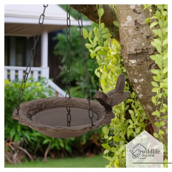 Hängendes Vogelbad mit dekorativem Rand und einem vogelähnlichen Griff, umgeben von Grün, mit dem Logo "wildlife home."