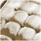 Nahaufnahme eines weichen, braunen Haustierbettes mit gepolstertem Stoff und sichtbaren Nähdetails.
