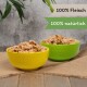 Zwei bunte Schalen, gefüllt mit Haustierfutter, eine gelbe und eine grüne, mit Text, der "100% Fleisch" und "100% natürlich" besagt.