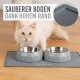 Zwei graue Haustierschalen mit geometrischem Design stehen auf einer grauen Matte, mit dem Text "Sauberer Boden dank hohem Rand."