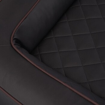 Nahaufnahme eines luxuriösen schwarzen Haustierbettes mit einem gesteppten Muster und einem braunen Rand, entworfen für Komfort und Stil.