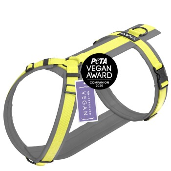 Ein graues und gelbes Hundegeschirr mit einem Etikett, das "PETA APPROVED VEGAN" liest.