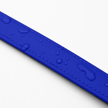 Nahaufnahme einer lebhaft blauen Haustierleine mit Wassertropfen auf ihrer Oberfläche, die ihr wasserdichtes Material und die Nähte zeigt.