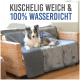 Ein flauschiger Hund, der auf einer gemütlichen, wasserdichten grauen Haustierdecke liegt, die über ein Rattansofa drapiert ist, mit dem Text "KUSCHELIG WEICH & 100% WASSERDICHT" darüber.