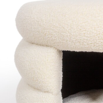 Ein gemütliches, cremefarbenes Haustierbett mit einer weichen, strukturierten Oberfläche und einem höhlenartigen Eingang, ideal für kleine Tiere.