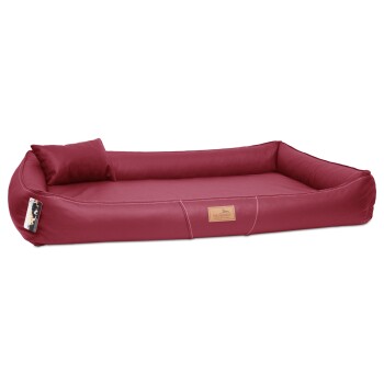 Rotes Haustierbett mit einer gepolsterten Rückenlehne und einem kleinen Kissen, mit einem Holzschild, auf dem "tierland" steht.