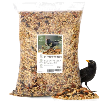 Ein 5 kg Beutel "Futtertraum Bodenfresser Spezial Mix" Vogelfutter mit einer Mischung aus Samen und Nüssen, mit einem Schwarzvogel daneben.