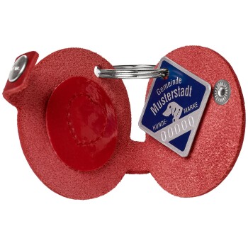 Roter Hundemarke mit einem silbernen Ring, mit einem blauen Identifikationsschild, das "Gemeinde Musterstadt Hunde-Marke 00000" liest.