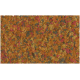 Bunte Fischfutterflocken in Orange-, Gelb-, Pink- und Grautönen, die über eine Oberfläche verstreut sind.