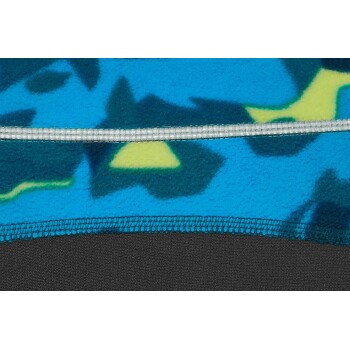 Nahaufnahme einer Haustierfleecejacke mit einem blauen und grünen Camouflage-Muster, mit einem schwarzen unteren Rand und einem silbernen Reißverschluss.