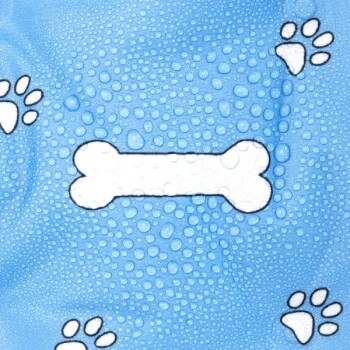 Ein blauer Stoff mit einem weißen Knochenmuster, umgeben von weißen Pfotenabdrücken, die alle mit Wassertropfen bedeckt sind.