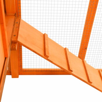 Holzrampe, die zu einem Haustiergehege führt, mit einem Gitterdrahtoberteil für Belüftung und Sicherheit.