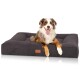 Ein glücklicher Australian Shepherd Hund liegt auf einem dunkelgrauen rechteckigen Hundebett mit einem Lederetikett, auf dem 'Knuffelwuff' steht.