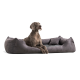 Ein großer, grauer Hund ruht sich bequem auf einem plüschigen, grauen Hundebett mit erhöhten Rändern aus, das ein gemütliches Design zeigt.