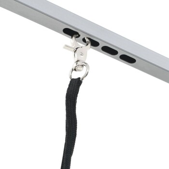 Eine Nahaufnahme eines Metallclips, der an einem schwarzen Riemen befestigt ist, der an einem silbernen Rahmen mit Löchern gesichert ist, wahrscheinlich für die Befestigung einer Hundeleine.