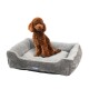 Ein flauschiger brauner Pudel sitzt in einem gemütlichen grauen Haustierbett mit erhöhten Rändern und zeigt Komfort und Stil.