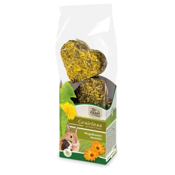 Grainless pet treats in heart shapes, featuring dried herbs and flowers, packaged in a clear bag with a green and white label.