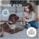 Ein Kind auf einem Teppich mit einem braunen Hund und einem Seilspielzeug. Text: "SICHER SPIELEN," "KEINE CHEMIE," "100% NATÜRLICHE BAUMWOLLE."