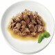 Biała talerz trzyma porcję wilgotnego, posiekanego mięsa w sosie, udekorowaną gałązką mięty.