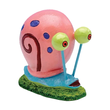 A colorful decorative snail figurine with a pink shell adorned with blue spots, large green eyes, and a blue base on a grassy patch.