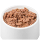 Eine weiße Haustierschüssel, gefüllt mit feuchtem, fein gehacktem Fleisch, das weich und leicht glänzend erscheint.