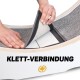 Eine Person demonstriert die abnehmbare Teppichschicht eines Haustierprodukts, mit dem Text "KLETT-VERBINDUNG" deutlich sichtbar.