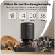 Ein schwarzer automatischer Futterspender für Haustiere mit zwei fressenden Katzen, der einen Timer von 14:00:36 zeigt. Text: "Füttere zwei Haustiere gleichzeitig ohne Futterstreitigkeiten."