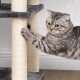 Eine graue getigerte Katze, die verspielt an einem Kratzbaum auf einem Katzenbaum kratzt, der weiche graue Plattformen und mit Sisal umwickelte Säulen hat.