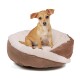 Ein kleiner Hund sitzt bequem in einem plüschigen, runden Hundebett mit einem weichen weißen Innenraum und einem braunen Außenraum.