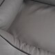 Eine Nahaufnahme eines weichen, grauen Haustierbettes mit einem plüschigen, gepolsterten Innenraum und schwarzem Piping entlang der Kanten.