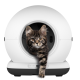 Braun getigertes Kätzchen, das aus der kreisrunden Öffnung einer weißen kugelförmigen automatischen Katzentoilette hervorkommt, Pfote ausgestreckt.