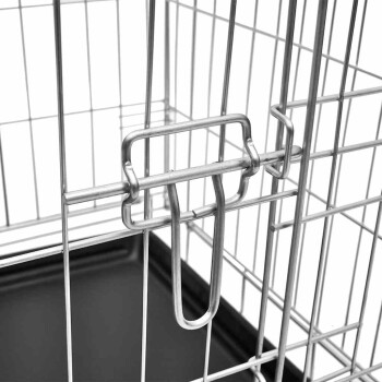 Nahaufnahme eines Metallverschlusses für eine Haustierbox, der den Verriegelungsmechanismus und die Drahtstruktur zeigt, mit einem sichtbaren schwarzen Kunststoffsockel darunter.