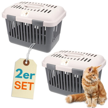 Zwei grau-rosa Kunststoff-Transportboxen mit Lüftungsschlitzen und Anhänger mit Aufdruck "2er SET", daneben sitzt eine rotgetigerte Katze.