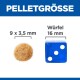 Bild, das ein Haustierfutterpellet (9 x 3,5 mm) mit einem blauen Würfel (16 mm) vergleicht. Text: "PELLETGRÖSSE" und "Würfel."
