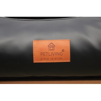 Schwarzes Haustierbett mit beigefarbenem, abgestepptem Etikett mit der Aufschrift PETLIVING 'place to enjoy' und einem Pfote-im-Haus-Logo.