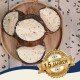 Ein Holzbrett zeigt drei runde Tierleckerlis mit einer cremigen Füllung und Samen, neben einem goldenen Abzeichen mit der Aufschrift "Beste Qualität."