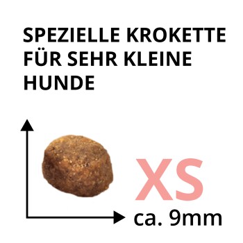 Braune Hundekroketten mit Größenpfeilen und sichtbarem Text ‚SPEZIELLE KROKETTE FÜR SEHR KLEINE HUNDE‘ und ‚XS ca. 9 mm‘.