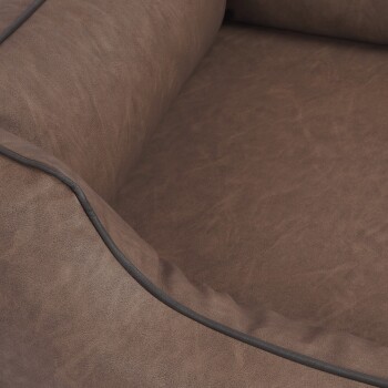 Eine Nahaufnahme eines weichen, braunen Haustierbettes mit einem plüschigen Innenraum und einem kontrastierenden schwarzen Rand entlang der Kanten.